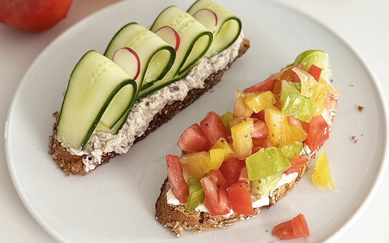 Tartine de rillettes garnie de rubans de concombre et radis, légumes de saison